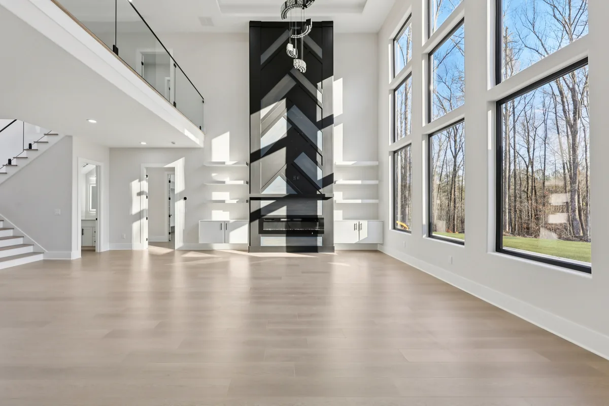 Two-story fireplace feature wall clad in black and white wood laid in a herringbone pattern, carried the full height to the ceiling