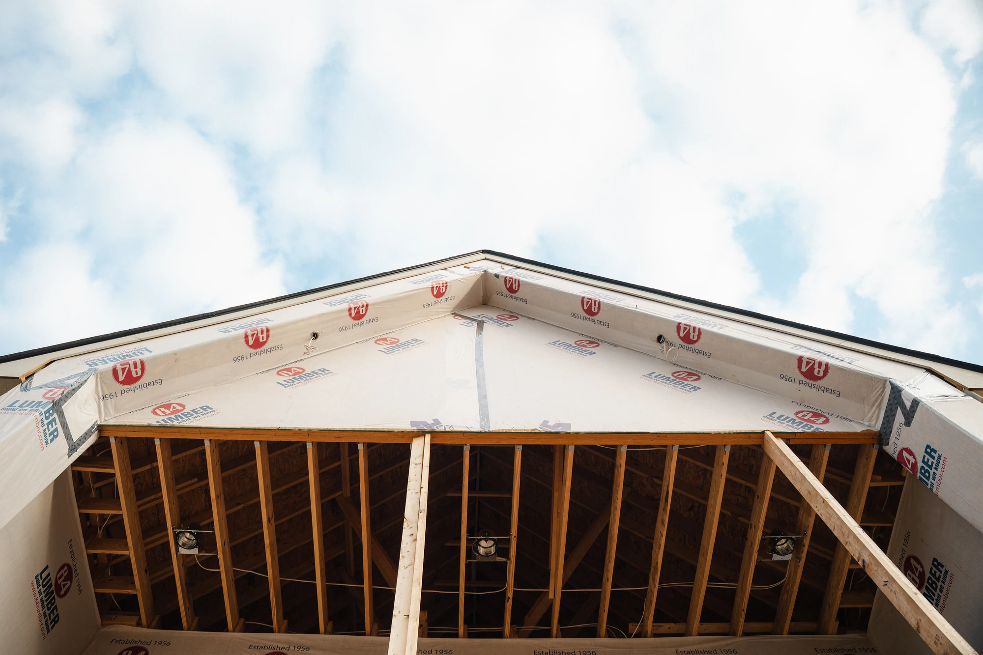 Upward view of a wrapped gable with exposed rafters beneath the roof overhang.