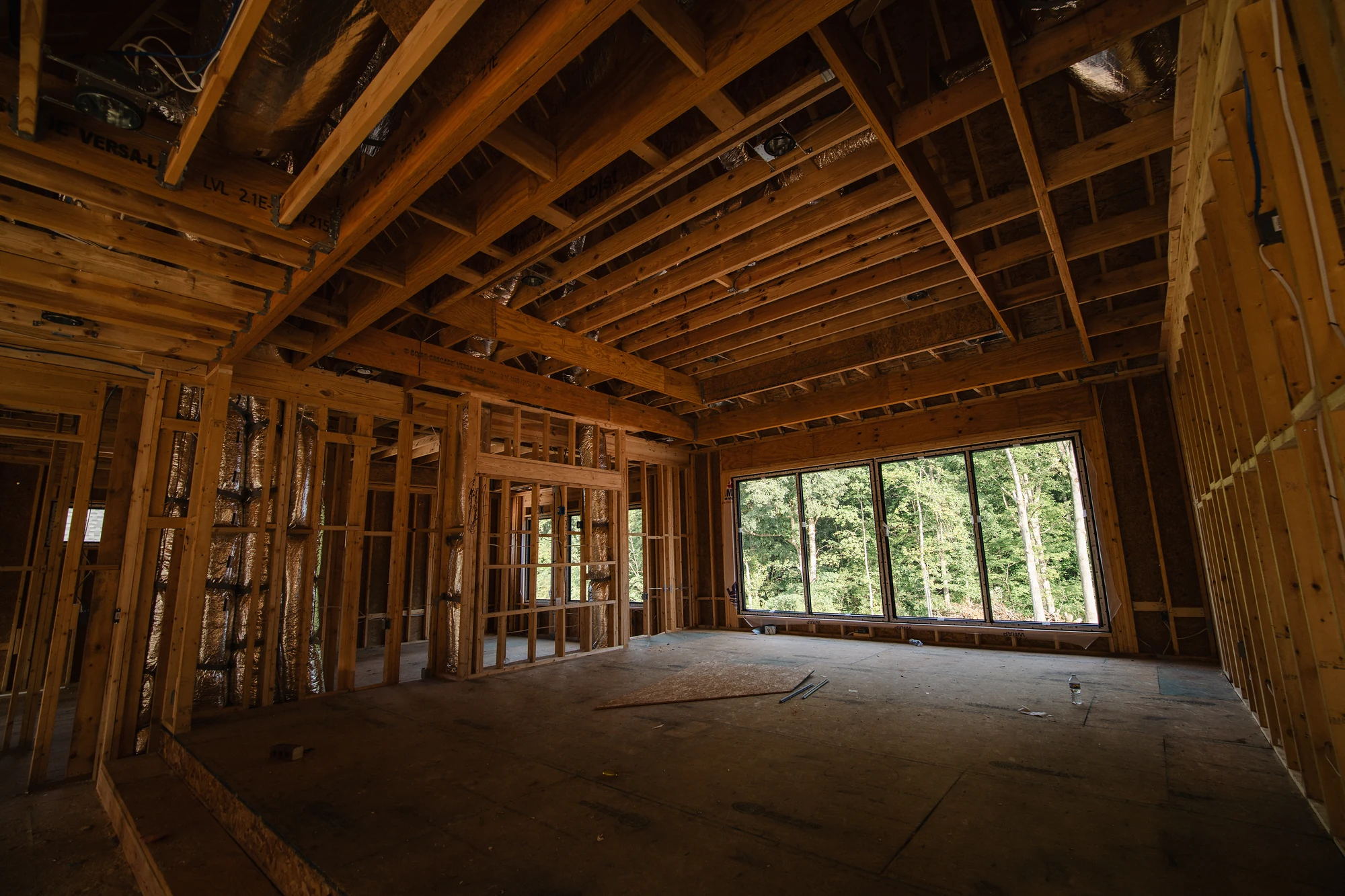 Large open framed interior with exposed ceiling joists and a wide bank of windows.