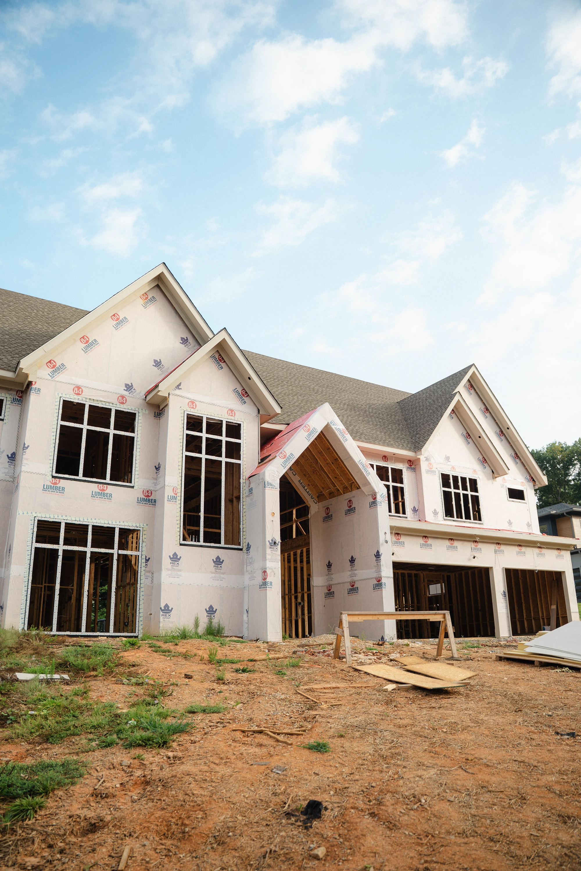 Angled exterior view of tall window openings, a projecting gabled canopy, and wrapped walls.