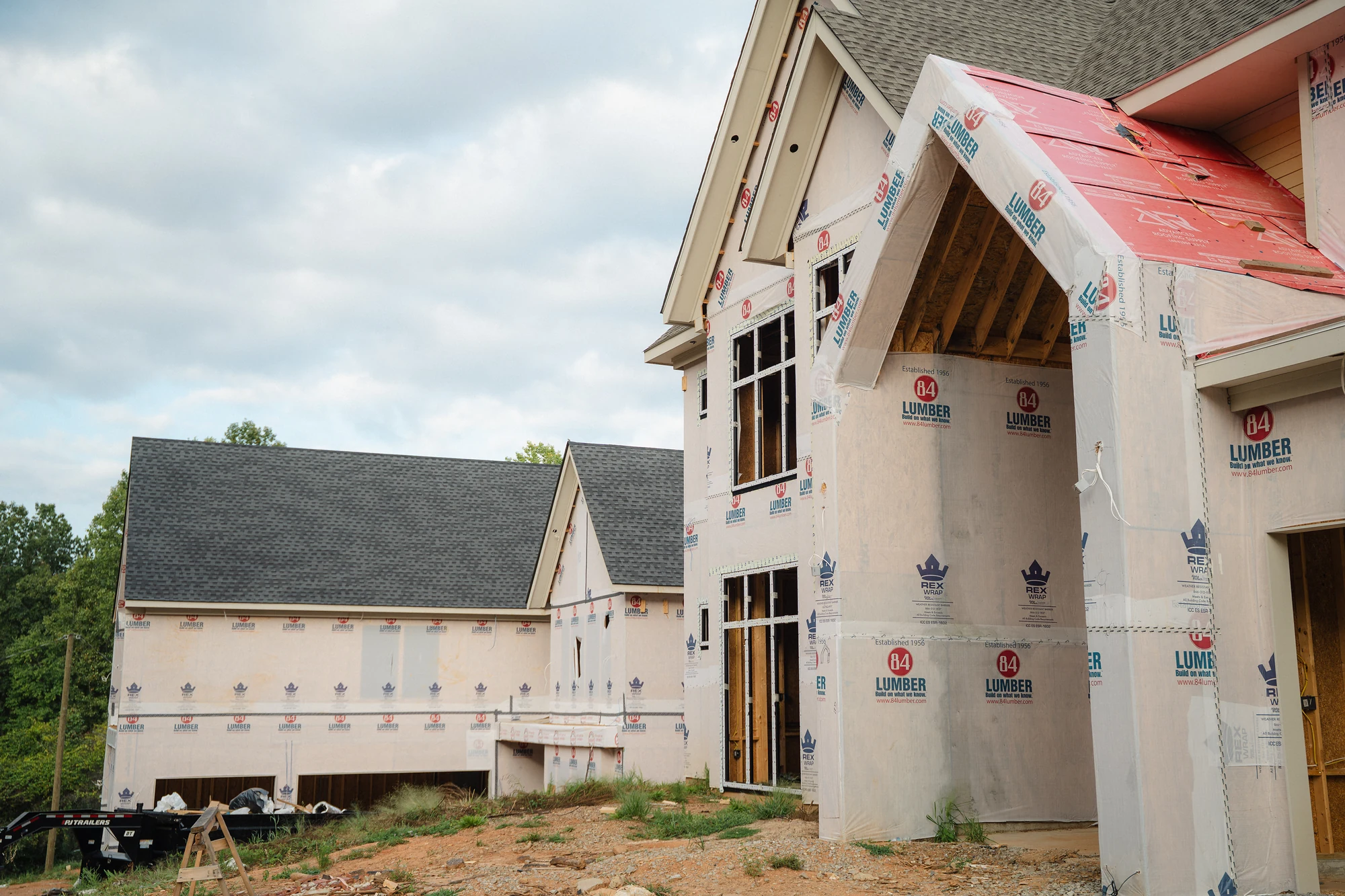 Exterior side view of adjoining rooflines, wrapped walls, and an open framed upper section.